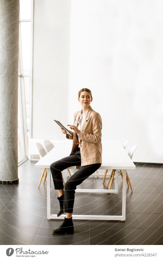 Junge Frau hält digitales Tablet in modernem Büro Erwachsener attraktiv schön Business Geschäftsfrauen Anzeige elektronisch Glück Beteiligung im Innenbereich