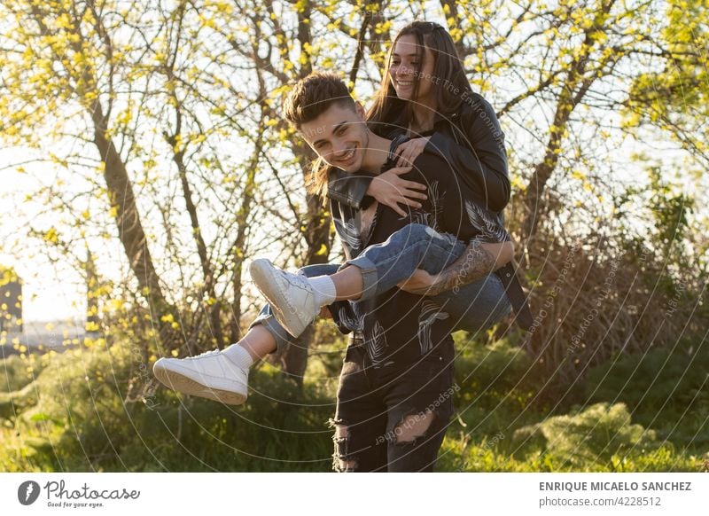 Frau reitet auf dem Rücken ihres Partners und hat Spaß auf dem Feld Frauen lustig Menschen Glück jung Mädchen Hintergrund romantisch Lächeln Fröhlichkeit Liebe