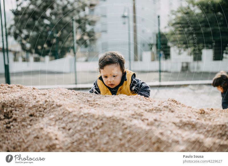 Kind klettert auf Sand Kindheit authentisch Abenteuer Spielen Kindheitserinnerung Leben Kleinkind Lifestyle Freude Mensch Farbfoto 1-3 Jahre Gefühle Kinderspiel