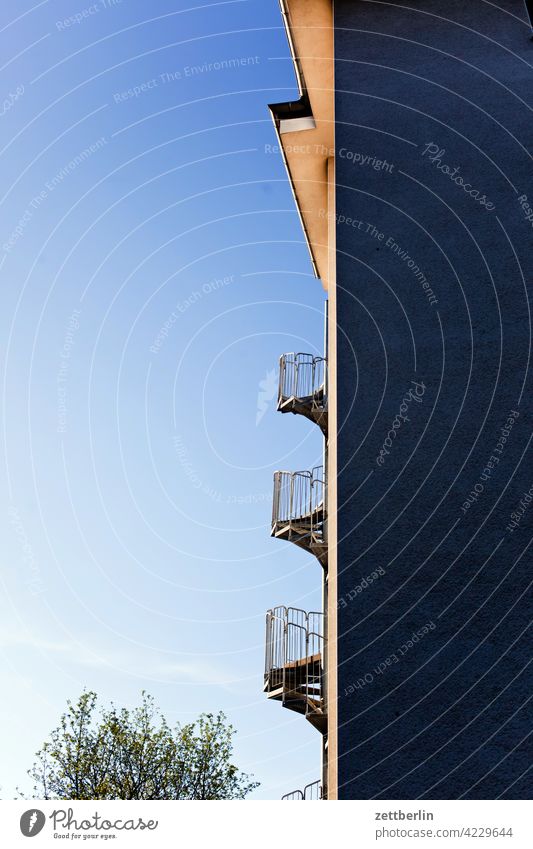 Außentreppe im Morgenlicht außentreppe wendeltreppe feuerschutz fluchtweg brandschutz haus wand hauswand fassade ecke winkel froschperspektive himmel wolkenlos