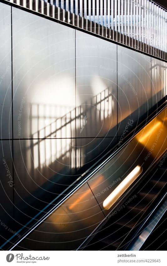 Rolltreppe rolltreppe aufwärts abwärts bahnhof bahnsteig verkehr öpnv wand wandverkleidung metall glanz geländer licht schatten handlauf beleuchtung schräg