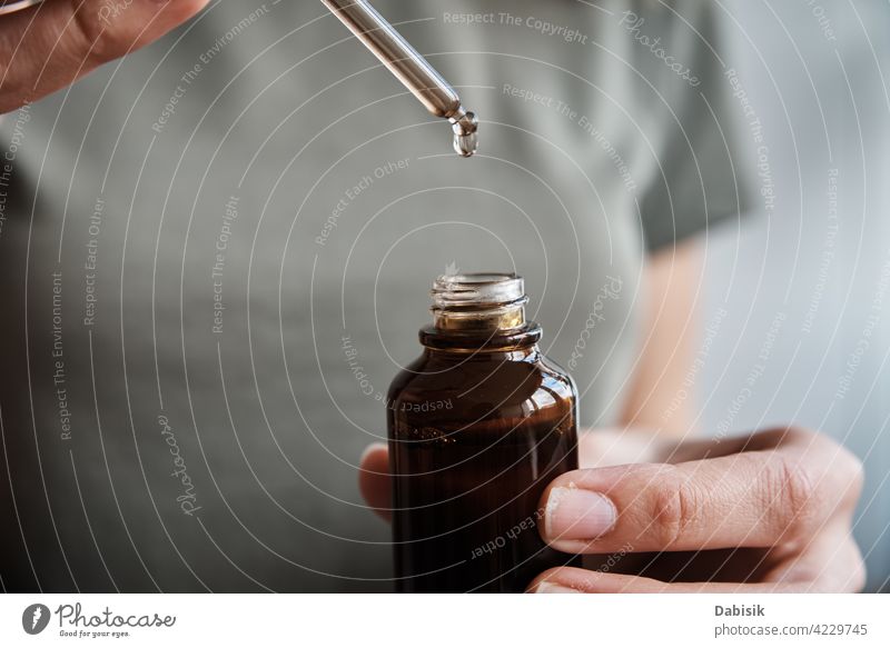 Frau hält Flasche mit kosmetischem Serum und ätherischem Öl Haut Essenz Pipette Tropfen Kollagen Glas übersichtlich Container Kosmetik Schönheit Chemikalie