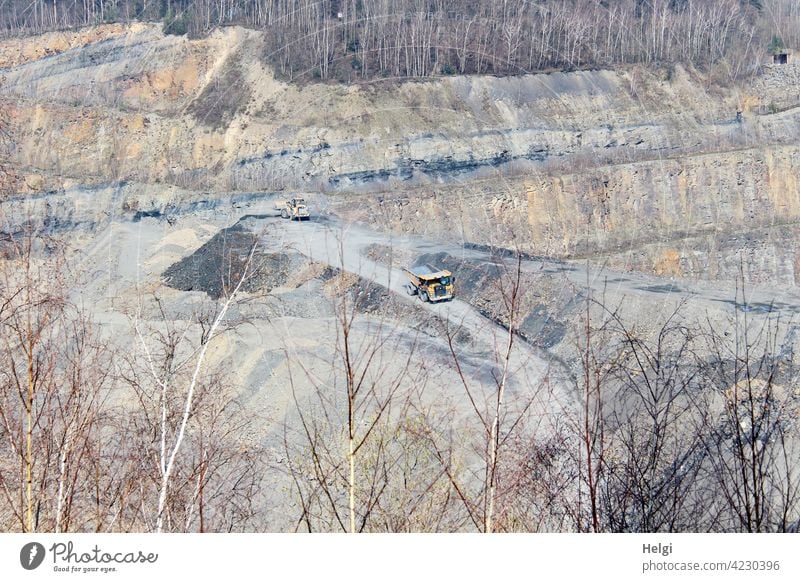 Blick in einen Steinbruch , ein Lastwagen und ein Radlader auf den Transportwegen Gestein Gesteinsschichten Abbau Sandstein Hartschiefer Tonschiefer Schiefer