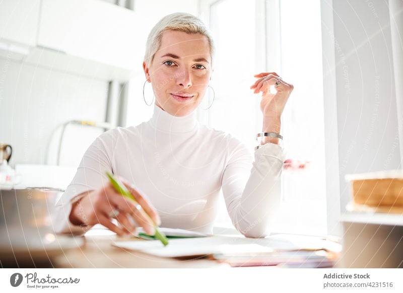 Astrologe lachend am Tisch im Lichthaus Lachen positiv feminin sorgenfrei Accessoire charismatisch Frau heimwärts Porträt Inhalt froh Glück Astrologie