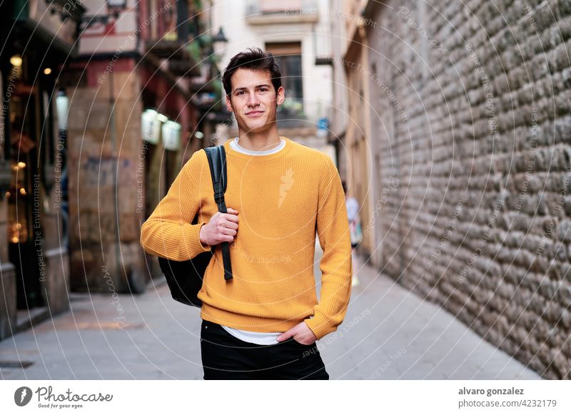 Porträt eines jungen Mannes, der im Freien auf der Straße steht. urban Großstadt Selbstvertrauen Rucksack Stehen posierend stylisch Beteiligung Schüler Blick