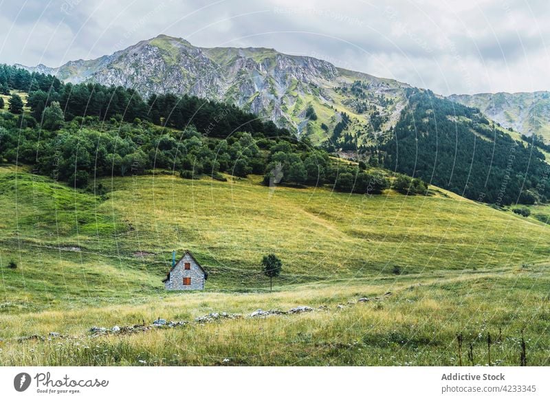 Häuser zwischen hohen Bergrücken unter bewölktem Himmel Landschaft Berge u. Gebirge Haus Natur Hochland wolkig Tal Hügel Atmosphäre Konstruktion wohnbedingt