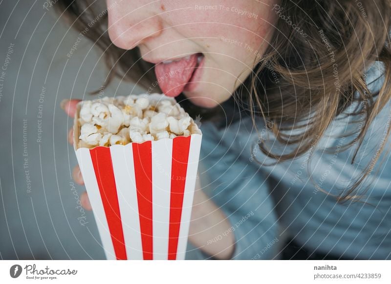 Frau hält einen Behälter voll mit Popcorn Mais Kino Filmmaterial altehrwürdig retro klassisch stilvoll rot weiß Versuchung Snack genießen Hand Lifestyle Leben