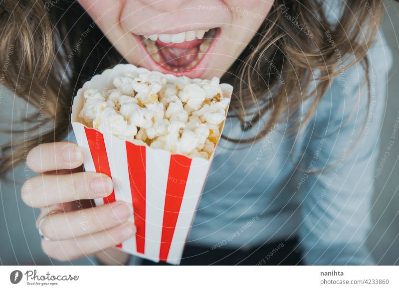 Frau hält einen Behälter voll mit Popcorn Mais Kino Filmmaterial altehrwürdig retro klassisch stilvoll rot weiß Versuchung Snack genießen Hand Lifestyle Leben