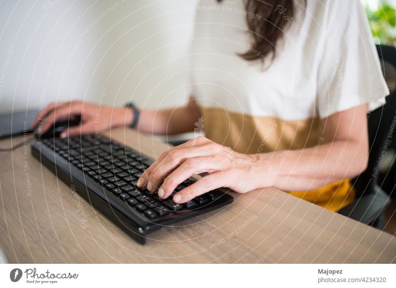 Nahaufnahme einer Frau, die zu Hause arbeitet. Hände auf der Tastatur und ein sauberer Schreibtisch Job pc Keyboard Tippen Hand Business Büro 40-50 Erwachsener