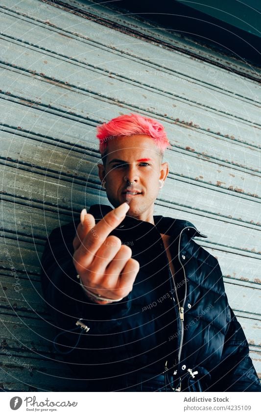 Queer Typ in stilvoller Kleidung mit Maniküre gegen graue Wand queer Stil Mode cool Identität akzeptieren Individualität Mann Porträt nageln zeigen gepolstert