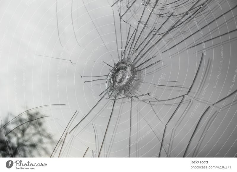 Glasbruch, von harten Anschlag hinterlassene Spur Glasscheibe Riss abstrakt Schaden Vandalismus Aggression Schaufenster Schadensfall Detailaufnahme kaputt