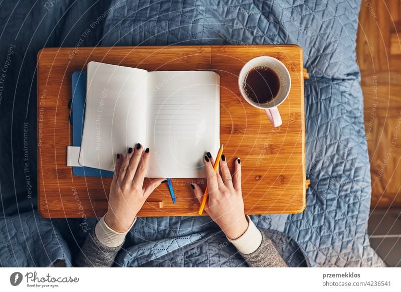 Schüler lernen zu Hause. Junge Frau macht Notizen, Lesen und Lernen von Notizblock. Mädchen schreiben Journal sitzen im Bett Bildung im Innenbereich arbeiten