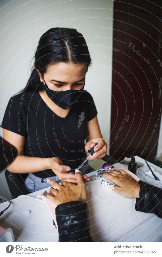 Meisterin benutzt Folie bei der Maniküre eines Kunden im Salon Frauen Gel Nagellack entfernen Schönheit Pflege Verfahren Klient Leckerbissen Spa nageln Dienst