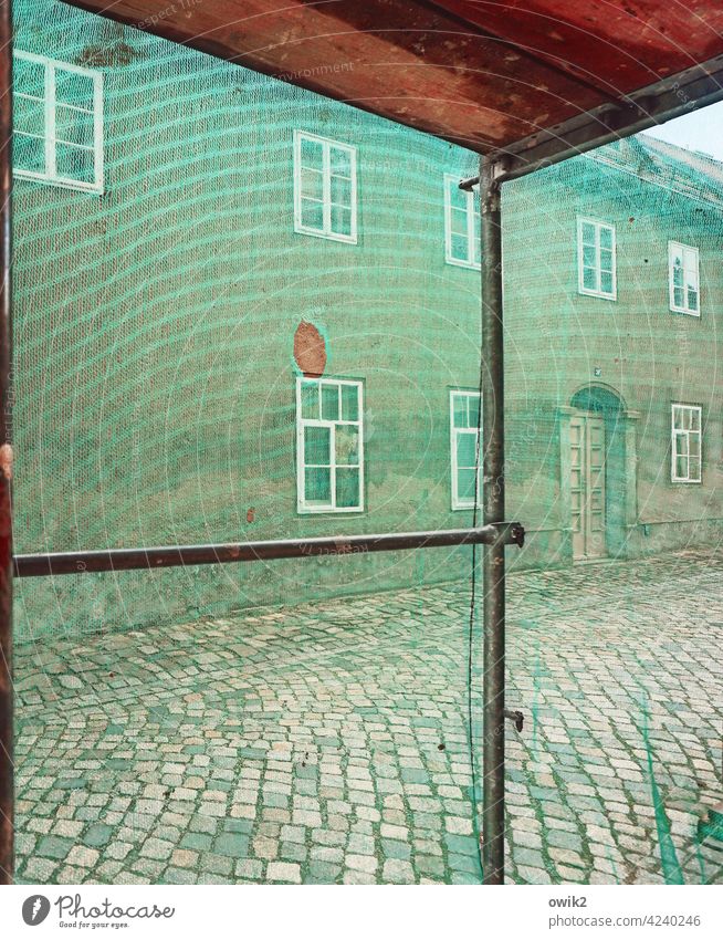 Laufmasche Gerüstplane Barriere Gasse Aussicht Straßenpflaster Häuser Renovieren Sanieren Sicherheit Textfreiraum oben Gerüstnetz komplex Mauer Handwerk bauen