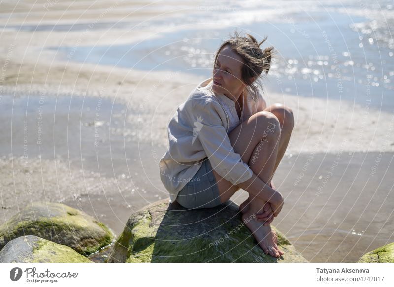 Frau sitzt in der Nähe von Meer, Blick zum Wasser Natur im Freien Wohlbefinden Erholung Achtsamkeit sich[Akk] entspannen Atmung MEER Ruhe Meditation Person