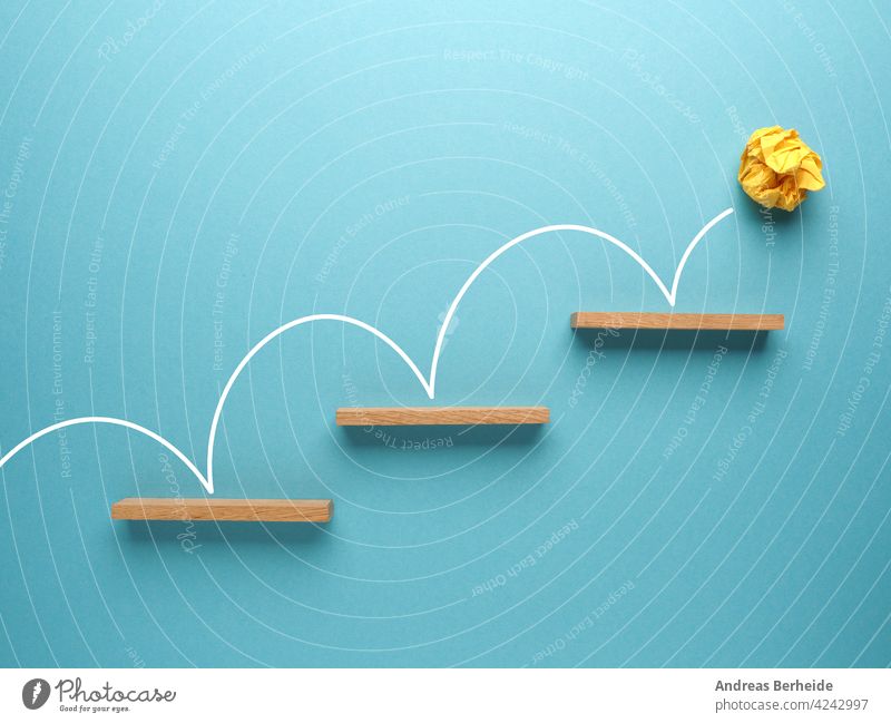 Gelbe zerknitterte Papierkugel springt die Treppe hinauf auf blauem Hintergrund Ball Inbetriebnahme Aufschwung Aktion Tor Erfolg finanziell Business Blöcke