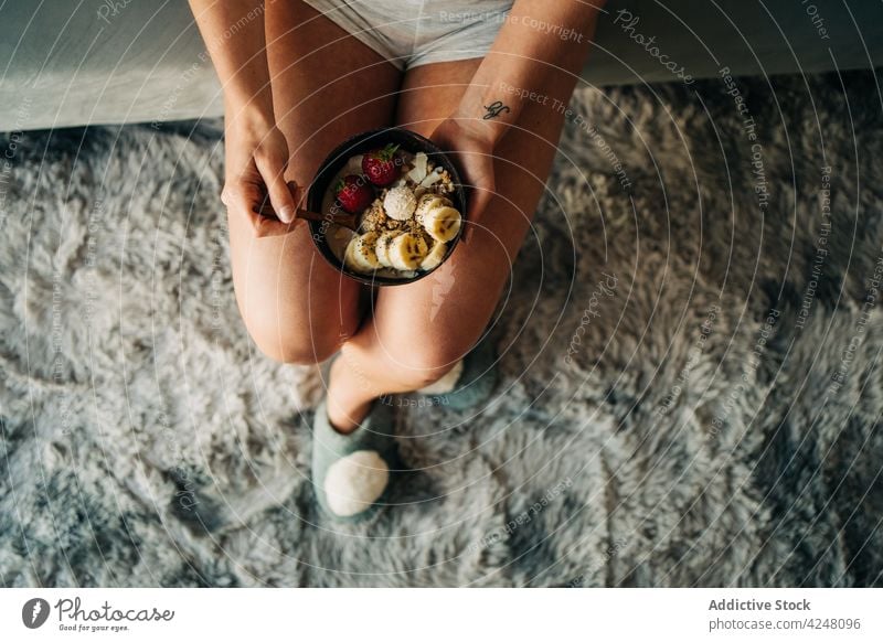 Unkenntlich gemachte Frau isst leckeren Brei mit Banane und Erdbeeren essen Haferbrei Frucht genießen Haferflocken Frühstück geschmackvoll gesunde Ernährung süß