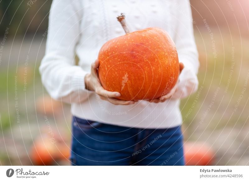 Frau hält Kürbis in Kürbis Patch Feld Halloween Natur Park Herbst fallen Erwachsener jung Menschen Glück Lächeln Spaß Kaukasier genießend Freude im Freien