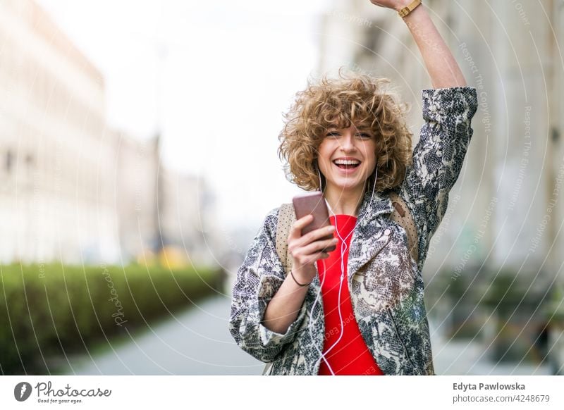 Junge Frau genießt Musik im Freien genießend Lifestyle jung Erwachsener Menschen eine Person lässig Kaukasier positiv sorgenfrei Glück Lächeln attraktiv schön