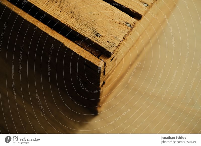 Holzkiste Ecke Nachaufnahme auf Fußboden Wohnen zuhause drinnen Kiste Laminat Lagerung vintage genagelt Kisten Farbfoto Menschenleer Außenaufnahme wohnen braun