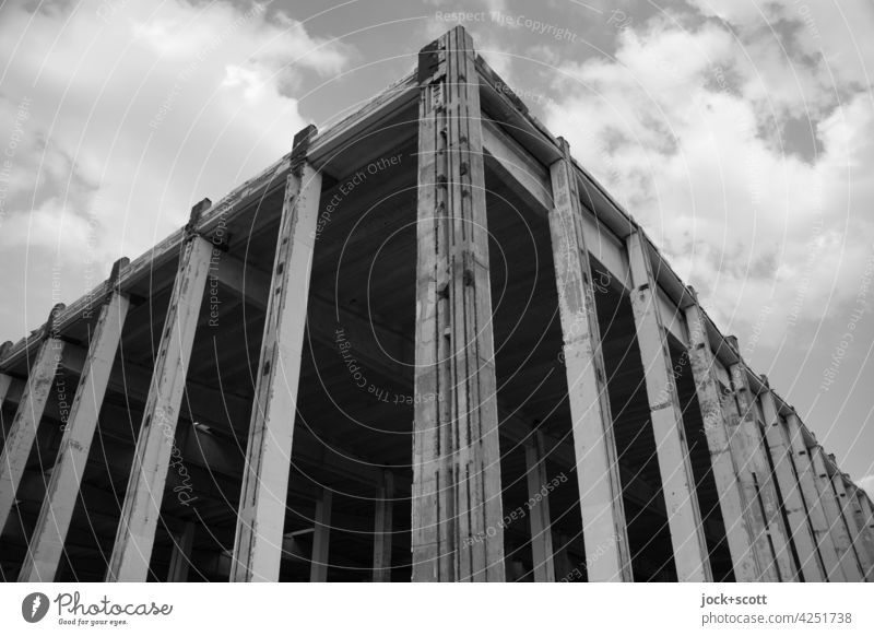 Hallenbau im Skelettbau Skelettbauweise Moderne Architektur Pfeiler Stahlbeton Bodenbelag Flachdach Gebäude Wolkenhimmel Schatten Lichtschein Silhouette