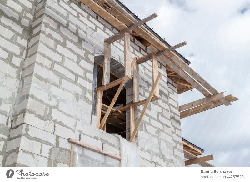 Nahaufnahme eines Gerüsts und eines im Bau befindlichen Hauses mit Halterungen für die Dachrinnen und das Wasserabflusssystem Wasserrinne Installation