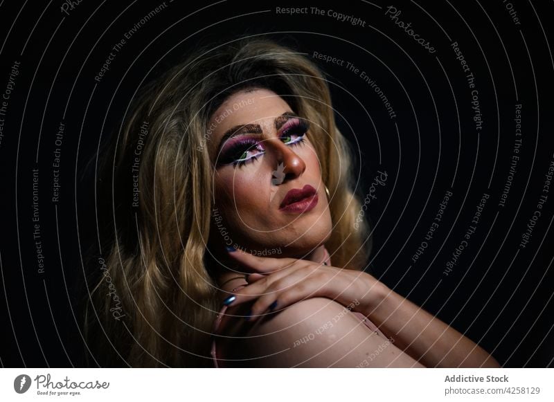 Stilvoller androgyner Mann in der Dunkelheit stehend feminin Drag Queen queer lgbtq exzentrisch seltsam Individualität ungewöhnlich dunkel informell provokant