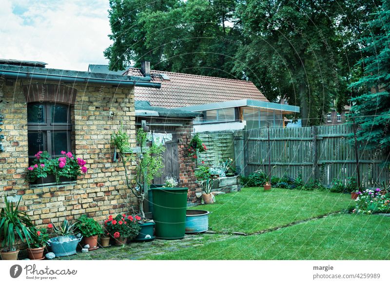 Ein Hinterhof  mit Blumentöpfen, Wäscheleine und Regenfass Gartenhaus Wiese Farbfoto Gras Zaun Sommer Nostalgie Fenster Gartenarbeit ruhig Idylle