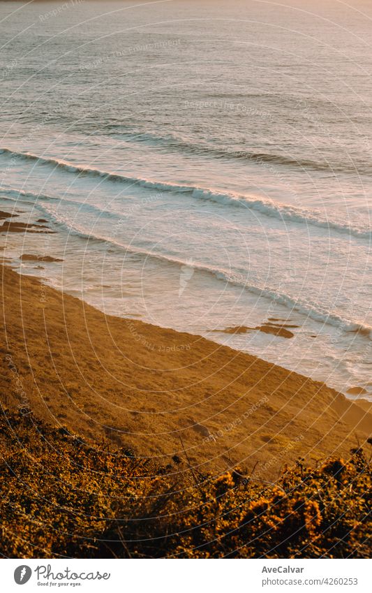 Luftaufnahme von einem massiven Strand mit Wellen während einer super sonnigen Sonnenuntergang auf Vintage-Töne Abend Abenddämmerung Horizont Sonnenaufgang