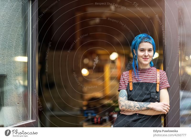 Selbstbewusste junge Handwerkerin in ihrer Werkstatt diy Hipster farbenfroh Behaarung Tattoos Frau Besitzer Beruf Dienst Kleinunternehmen Mitarbeiter arbeiten