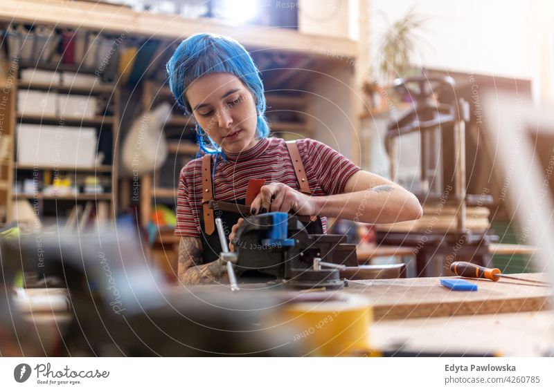 Kunsthandwerkerin bei der Arbeit in ihrer Werkstatt diy Hipster Behaarung Tattoos Frau Besitzer Beruf Dienst Kleinunternehmen Mitarbeiter arbeiten Arbeitsplatz