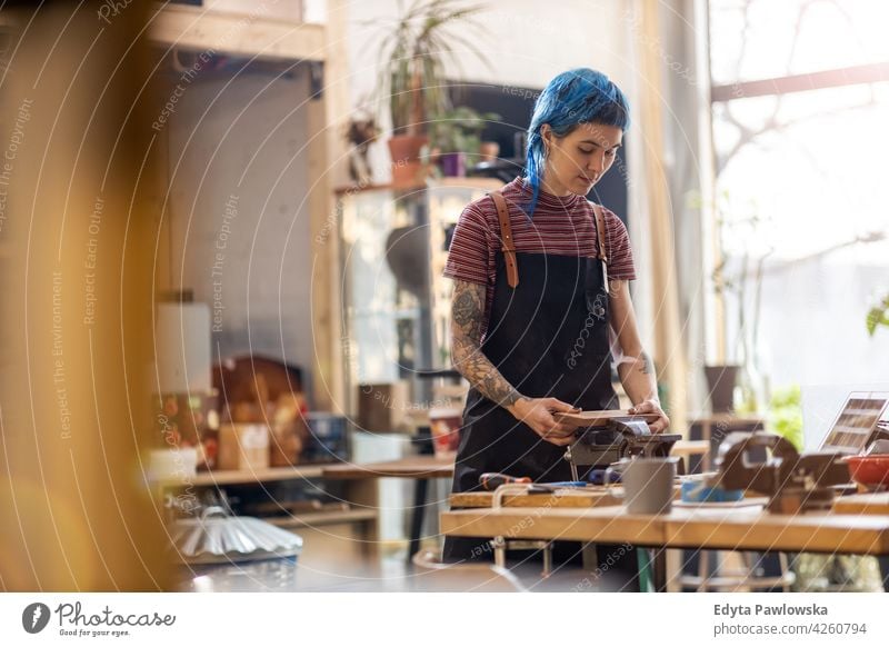 Zimmermannsfrau in ihrer Werkstatt diy Hipster Behaarung Tattoos Frau Besitzer Beruf Dienst Kleinunternehmen Mitarbeiter arbeiten Arbeitsplatz Flugzeugwartung