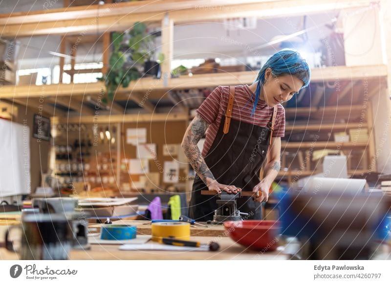 Junge Handwerkerin bei ihrer Arbeit diy Hipster Behaarung Tattoos Frau Besitzer Beruf Dienst Werkstatt Kleinunternehmen Mitarbeiter arbeiten Arbeitsplatz