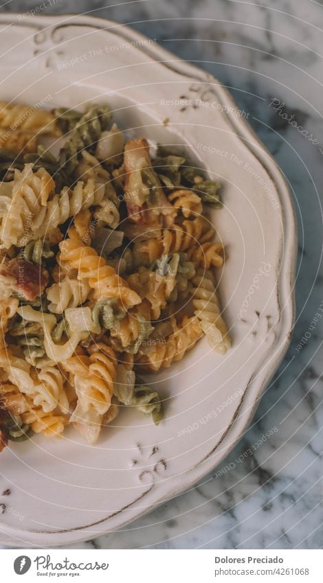 Ein Teller Nudeln mit Sahne und Speck Penne Fettuccin Parmesan Sahnesauce Spaghetti Rezept selbstgemacht Paprika hölzern mediterran Stein Würzig Italienisch