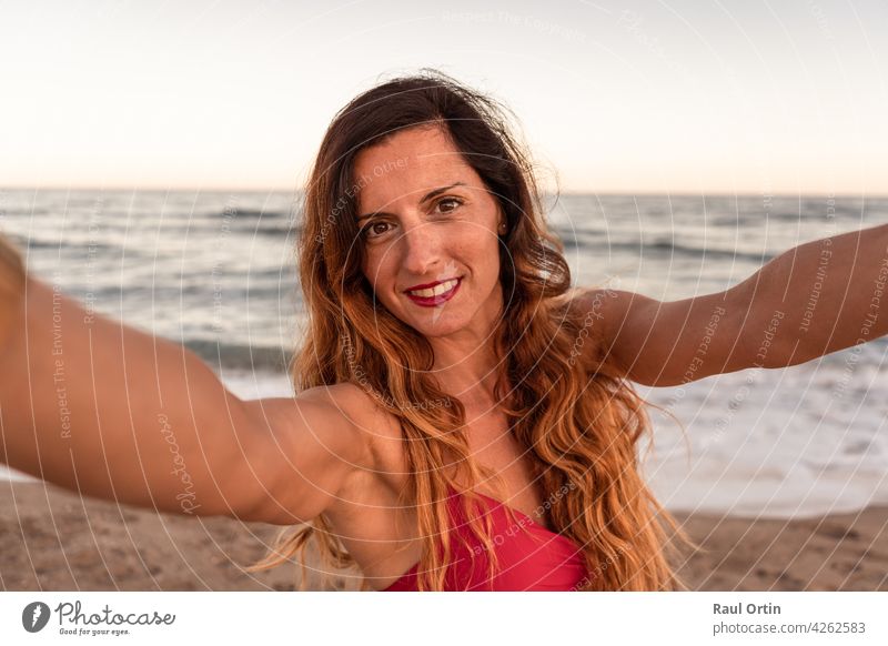 Hübsche stilvolle Frau, die Spaß hat, ein Selfie am Strand bei Sonnenuntergang zu machen. MEER Sommer Glück Fotokamera Natur im Freien Lifestyle verwenden