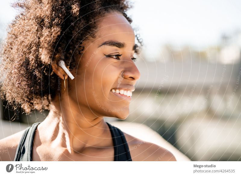 Afro-Athletin, die im Freien steht. Fitness Frau Sport Übung aussruhen Pause sich[Akk] entspannen genießend Erholung Freizeit Großstadt sportlich entspannend