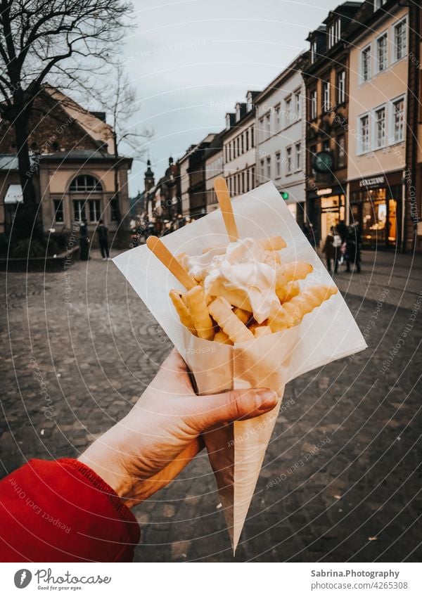 Eine Portion Pommes Frites mit Mayonnaise in der linken Hand in der Hauptstraße, Heidelberg Pommes frites Essen Fastfood Lebensmittel Fett Baden-Württemberg