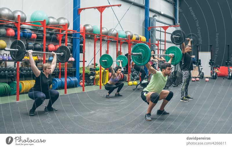 Menschen, die Gewichtheben üben und Gewichte in der Turnhalle heben Fitnessstudio Menschengruppe Heben Kurzhantel Gerät Greifen Sauberkeit Ruckeln