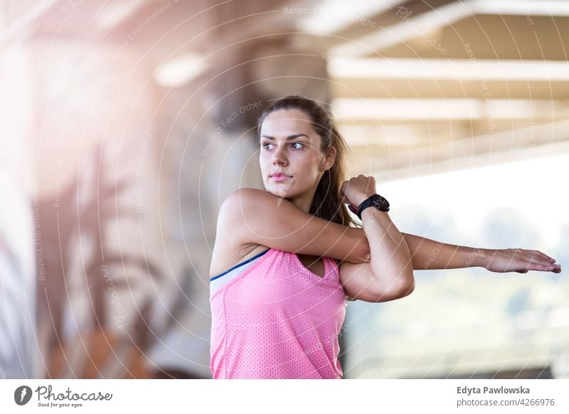 Junge Frau macht Fitness-Übung im städtischen Bereich Energie trainiert. Sport Aktivität Vitalität Körper Turnkleidung Training anstrengen beweglich