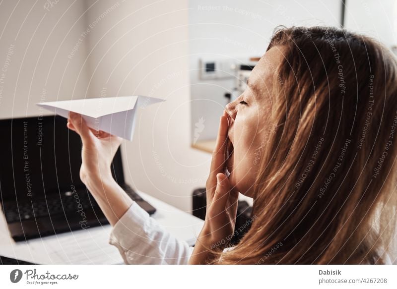 Frau spielt mit Papier Ebene im Home-Office. Prokrastinieren bei der Fernarbeit prokrastinieren freiberuflich abgelegen online Arbeit heimwärts LAZY Business