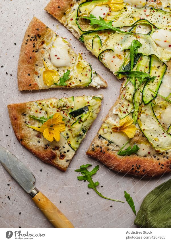 Leckere Pizza mit Zucchinischeiben auf grauem Hintergrund Käse Rucola Sesam Lebensmittel Mittagessen Gewürz gebacken lecker Gemüse Messer Squash Blume Scheibe