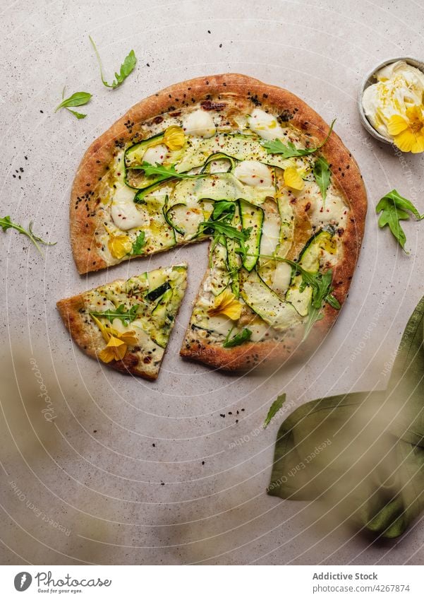 Leckere Pizza mit Zucchinischeiben auf grauem Hintergrund Käse Rucola Sesam Lebensmittel Mittagessen Gewürz gebacken lecker Gemüse Messer Squash Blume Scheibe