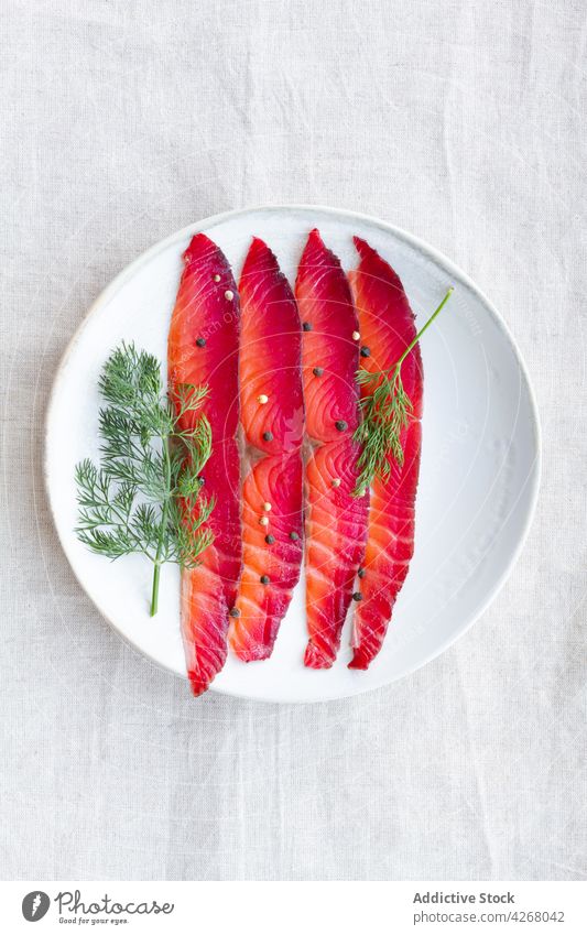 Geräucherte Lachsscheiben auf dem Teller gravlax Fisch Amuse-Gueule Pfefferkörner Dill Rote Beete geräuchert geheilt mischen frisch Kraut natürlich Protein