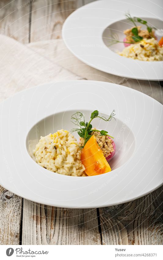 Risotto mit Meeresfrüchten. Ei mit geräucherter Makrelenpastete. Honig-Orangen-Tomate. Gourmet-Küche. Food-Fotografie und Styling. Mediterrane Küche. Vertikale Aufnahme. Nahaufnahme. Köstlich und gesund essen