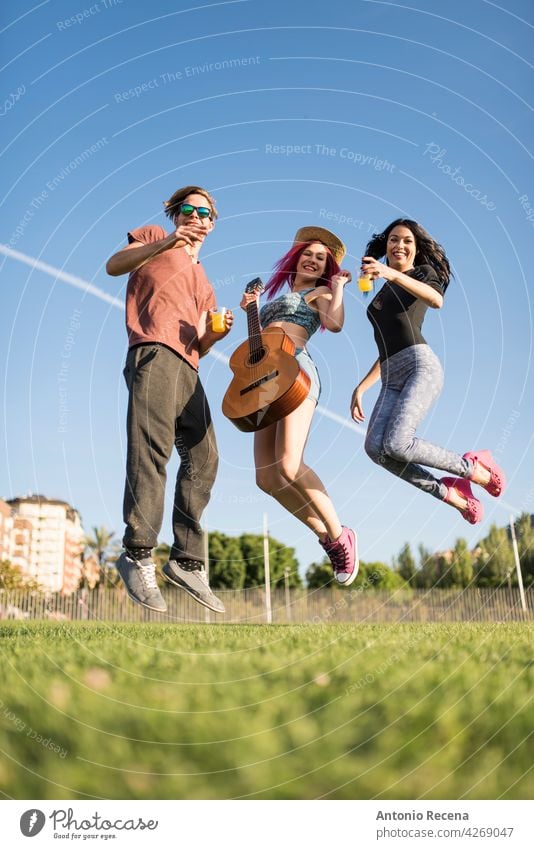 Eine Gruppe von Freunden genießt ihre Freizeit im Park, spielt Gitarre und genießt Frau jung attraktiv 20s Freude Menschen Person Jugend urban Frauen hübsch