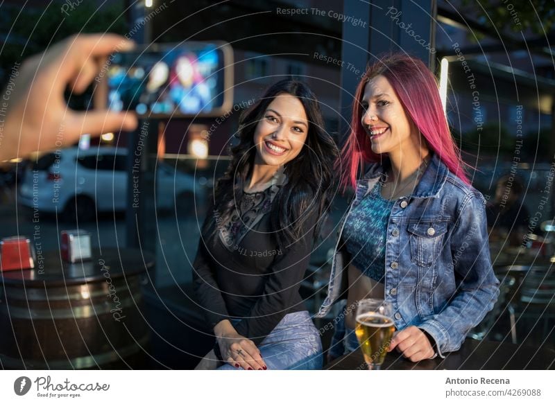 Eine Hand nehmen zwei Frauen Telefon Fotografie jung attraktiv 20s Freude Menschen Person Jugend urban hübsch hübsche Menschen im Freien Großstadt Lächeln Glück