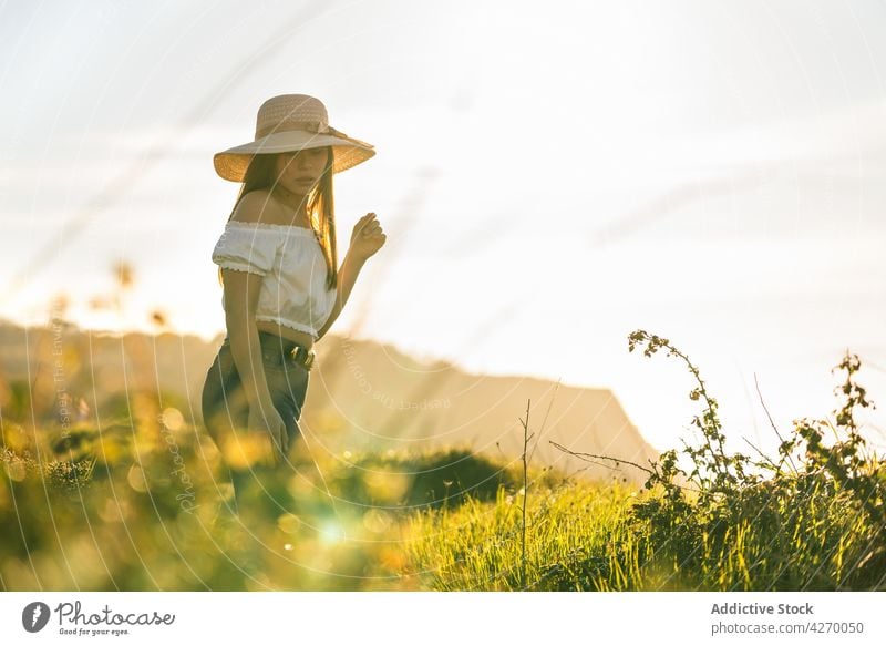 Frau auf grüner Wiese stehend Rasen verträumt Landschaft friedlich Sommer Stil sensibel Natur Gelassenheit grasbewachsen trendy Vorschein ruhig Jeanshose Feld