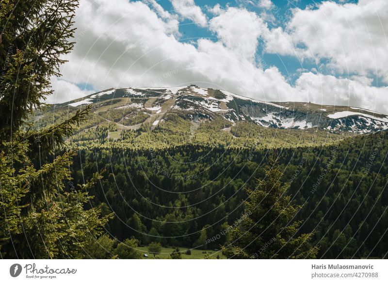 schöne Bergkette mit Schnee im Frühsommer Hintergrund blau Wolken kalt Land Landschaft Feld Wald Gras grün hoch wandern Wahrzeichen Reittier Berge u. Gebirge