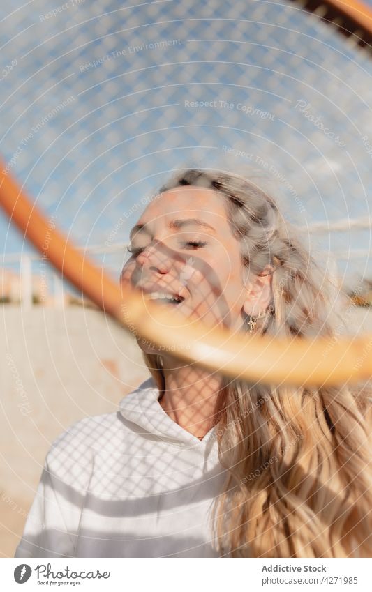 Frau mit geschlossenen Augen hält Tennisschläger auf der Straße Remmidemmi positiv froh Glück Lächeln sportlich Gerät jung Inhalt Lifestyle sorgenfrei angenehm