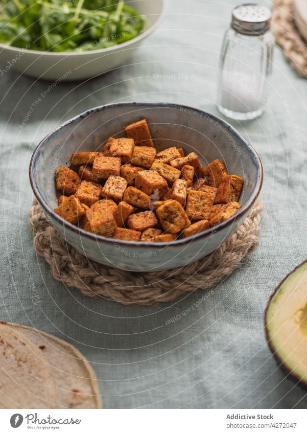 Gebratener Tofu in Schüssel auf Tisch mit Salzstreuer Bohnenquark Lebensmittel Bestandteil gebraten Produkt natürlich Orientalisch Würfel Schalen & Schüsseln